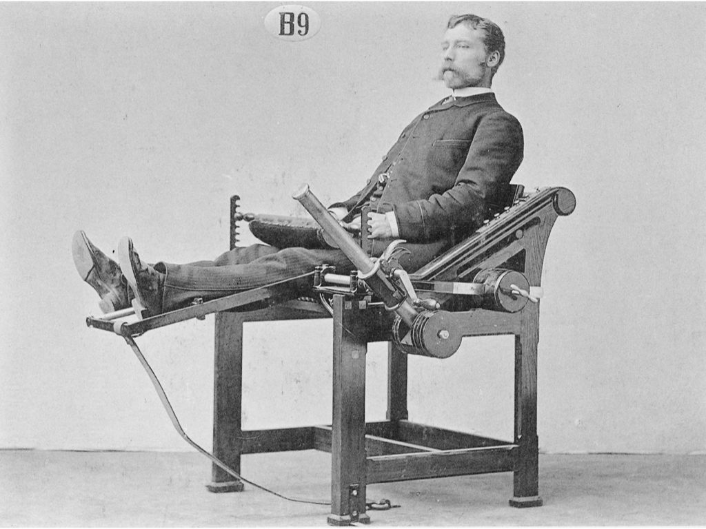 Moustachioed man at old fashioned exercise machine with a big lever
